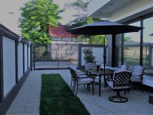 a patio with a table and chairs and an umbrella at ALEXYS TOP RESIDENCE in Mamaia Sat/Năvodari