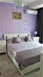 a bedroom with a large bed with purple walls at ALEXYS TOP RESIDENCE in Mamaia Sat/Năvodari