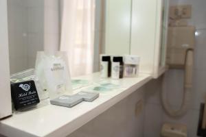 un bancone del bagno con prodotti esposti davanti a uno specchio di HOTEL POSTA Dépendance a Chianciano Terme