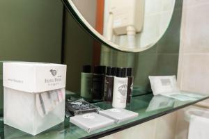 un bancone del bagno con uno specchio e alcuni prodotti su di esso di HOTEL POSTA Dépendance a Chianciano Terme