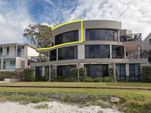 a large building with a yellow stripe on it at 2 137 Soldiers Point Road luxury unit on the waterfront with aircon and free unlimited WiFi in Salamander Bay