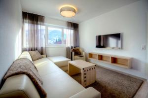 ein Wohnzimmer mit einem Sofa und einem TV in der Unterkunft Sport Chalet Maria Alm in Maria Alm am Steinernen Meer