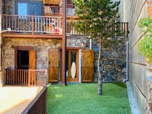 une maison avec une cour avec un arbre et un balcon dans l'établissement PROBER-INCLES, à Soldeu
