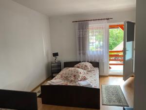 ein kleines Schlafzimmer mit einem Bett und einem Fenster in der Unterkunft Casa Gabriela in Sovata
