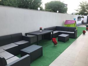 un patio con sofás, una mesa y flores en Vila Marylou Eforie Nord en Eforie Nord