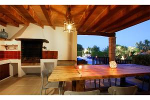 una gran mesa de madera en un patio con chimenea en Villa Crever, en Pollensa