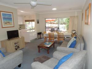 a living room with two couches and a television at Adriana 3 unit with a backyard in Shoal Bay