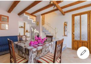 a dining room with a table with pink flowers on it at Fabrizia Apartment in Castellammare del Golfo