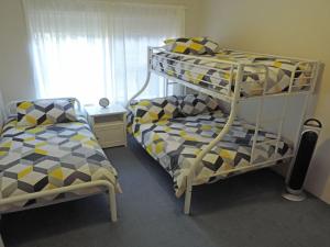 a bedroom with a bunk bed and a bed and a bunk bed at Adriana 3 unit with a backyard in Shoal Bay