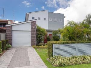 una casa con un garaje blanco y una valla en 7a Judith Street stunning duplex with ducted air conditioning, en Corlette