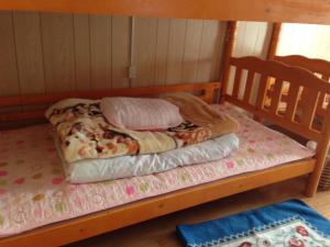 Litera con 2 almohadas encima en Goto Guest House Utojuku en Goto