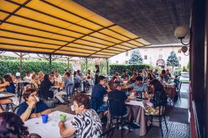 un grupo de personas sentadas en mesas en un restaurante en Il Leone D'Oro, en Telgate