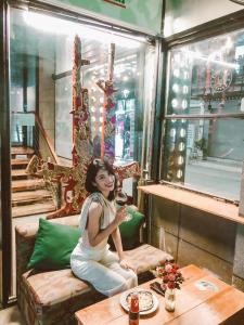 a young woman sitting on a couch in a restaurant at DMZ Hostel in Hue