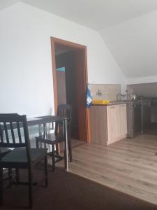 a room with a table and chairs and a kitchen at Apartament 107 B, Noclegi pod dobrym Aniolem in Kudowa-Zdrój