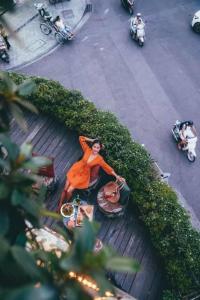 a woman in an orange dress sitting on a table at DMZ Hostel in Hue