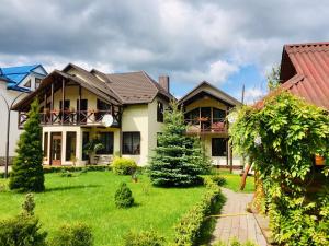 a house with a green lawn in front of it at Villa Diola in Kosiv