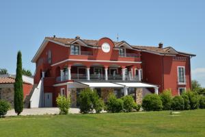 una grande casa rossa con un ampio cortile di Villa Nadar ad Altopascio