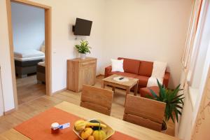 ein Wohnzimmer mit einem Sofa und einem Tisch in der Unterkunft Appartements Dullnig in Flattach