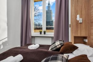 - une chambre avec un lit et une fenêtre avec vue dans l'établissement Warsaw City Center Apartments by Renters, à Varsovie