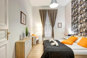 ブダペストにあるStandard Apartment by Hi5 - Weiner Leoのベッドルーム1室(オレンジ色の枕が付いたベッド1台付)