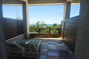 鹽寮村的住宿－浪花一朵朵民宿，阳台配有椅子,享有海景。