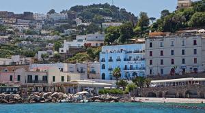 a group of buildings on a hill next to a beach at Relais Maresca Luxury Small Hotel & Terrace Restaurant in Capri