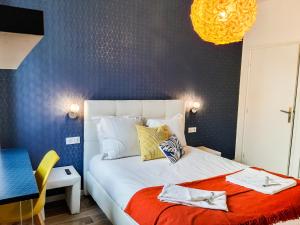 1 dormitorio con cama blanca y pared azul en Suite & Lake - Proche du Lac d'Annecy, en Annecy