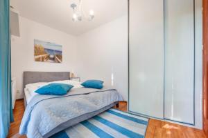 Un dormitorio con una cama con almohadas azules. en Apartamenty Sun & Snow Sikorskiego, en Kołobrzeg