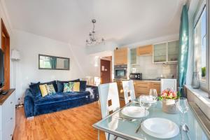 sala de estar con sofá azul y mesa en Apartamenty Sun & Snow Sikorskiego en Kołobrzeg