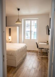 Schlafzimmer mit einem Bett, einem Schreibtisch und einem Fenster in der Unterkunft Suite & Lake - Proche du Lac d'Annecy in Annecy