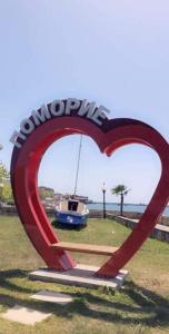 a sign in the shape of a heart with a boat at Апартаменти Бриз 1 in Pomorie