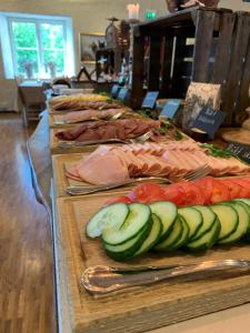 um buffet de alimentos com tomates pepinos e carne em Öster Malma Hotel em Marieberg