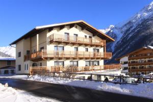 a building in the snow with mountains in the background at Haus Montjola in Sölden