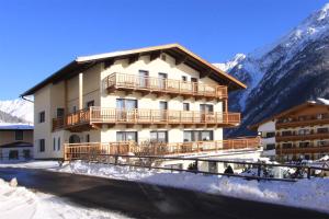 ein Gebäude im Schnee mit Bergen im Hintergrund in der Unterkunft Haus Montjola in Sölden