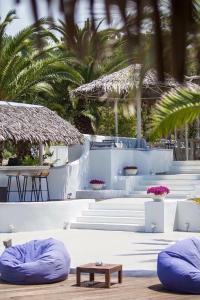 a group of white steps with chairs and tables and palm trees at Kohylia by La Scala Beach in Limenas