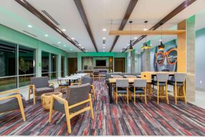 La Quinta by Wyndham Altoona Des Moines في ألتونا: منطقة لتناول الطعام مع طاولات وكراسي في مبنى