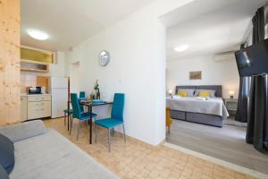 - un salon avec un lit, une table et des chaises dans l'établissement Apartment Stella old town Trogir, with balcony, à Trogir