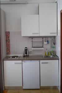 - une cuisine avec des placards blancs et un évier dans l'établissement Apartment Manda, à Zadar