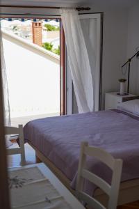 - une chambre avec un lit et une grande fenêtre dans l'établissement Apartment Manda, à Zadar
