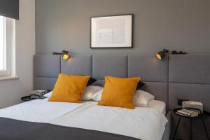 - une chambre avec un lit et 2 oreillers jaunes dans l'établissement Apartments Valentina, à Bol