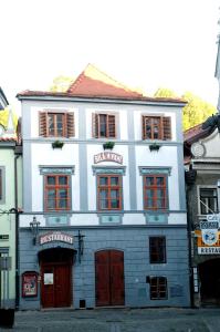 a large building with a clock on the front of it at Ubytování u BÍLÉ PANÍ in Český Krumlov
