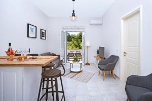 Il comprend une cuisine et un salon avec une table et des chaises. dans l'établissement Domus Lux Houses by Konnect, à Corfou