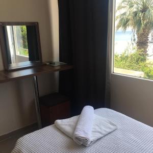 a room with a bed with a mirror and a window at VİLLA FUAT in Erdek