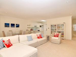 a living room with a white couch and chairs at Bay Parklands 32 fantastic unit with air conditioning pool tennis court and spa in Shoal Bay