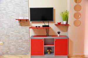 a red entertainment center with a television on top at Apartmani Ćetković in Kotor
