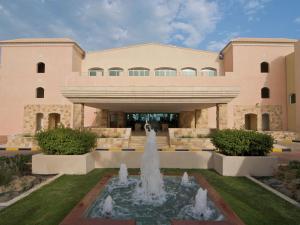 ein Gebäude mit einem Brunnen vor einem Gebäude in der Unterkunft Mövenpick Hotel & Resort Al Bida'a in Kuwait