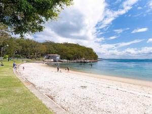 ネルソン・ベイにあるCollendina 4 fantastic water views and sea breezesの砂浜と水上を歩く人々のいる浜