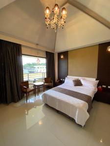 Un dormitorio con una cama grande y una lámpara de araña. en Lan Tian Homestay, en Jiaoxi