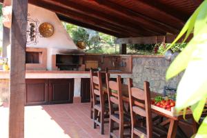 une cuisine extérieure avec des chaises en bois et une table dans l'établissement Villa con piscina Le Due Querce, à Bosco