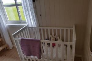 a white crib in a room with a window at Lofoten- Enjoy the Nature-With a beautiful beach in Napp